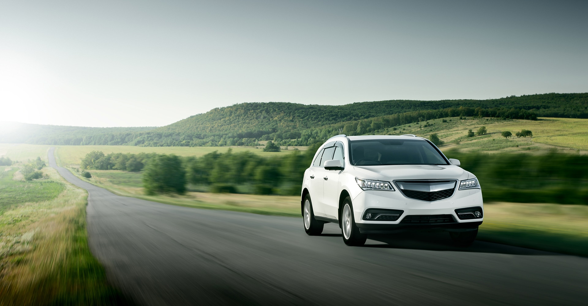 Conduite sur autoroute : voyage et coucher de soleil doré. Mains sur le volant d'une voiture, conduisant sur l'autoroute au coucher du soleil. Le soleil brille fortement à travers le pare-brise.