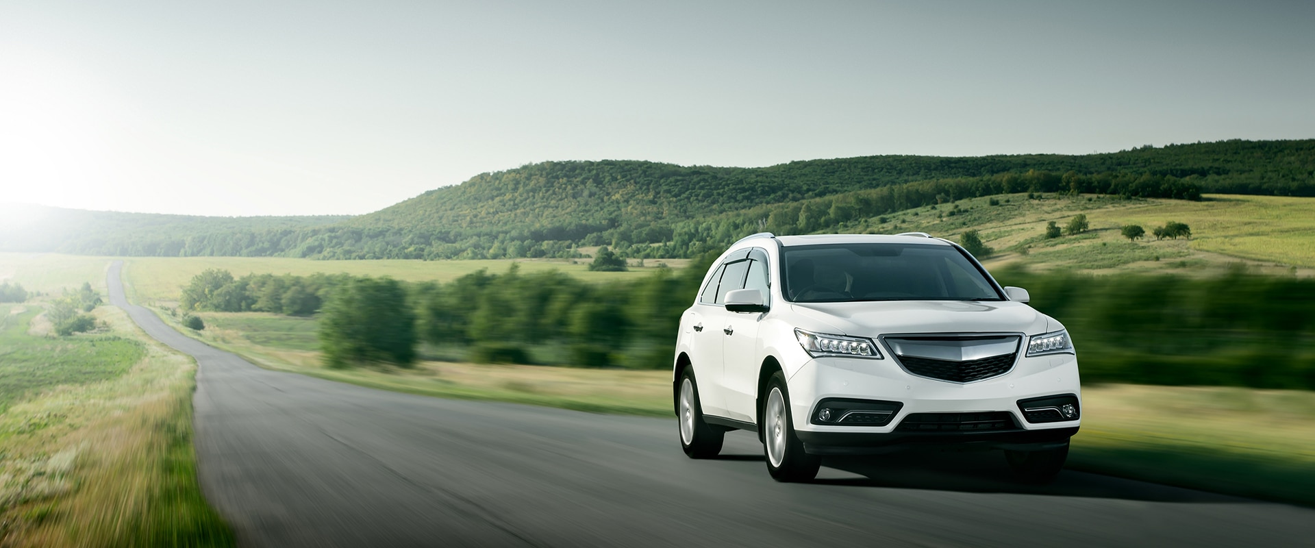 Conduite sur autoroute : voyage et coucher de soleil doré. Mains sur le volant d'une voiture, conduisant sur l'autoroute au coucher du soleil. Le soleil brille fortement à travers le pare-brise.
